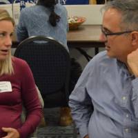 An alumna and a faculty member engage in conversation with one another at the Academic Major Fair.